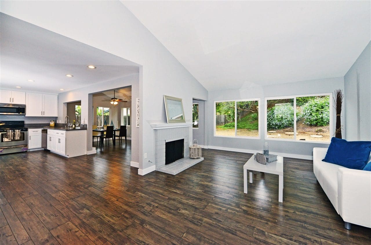 A living room with hard wood floors and white walls.