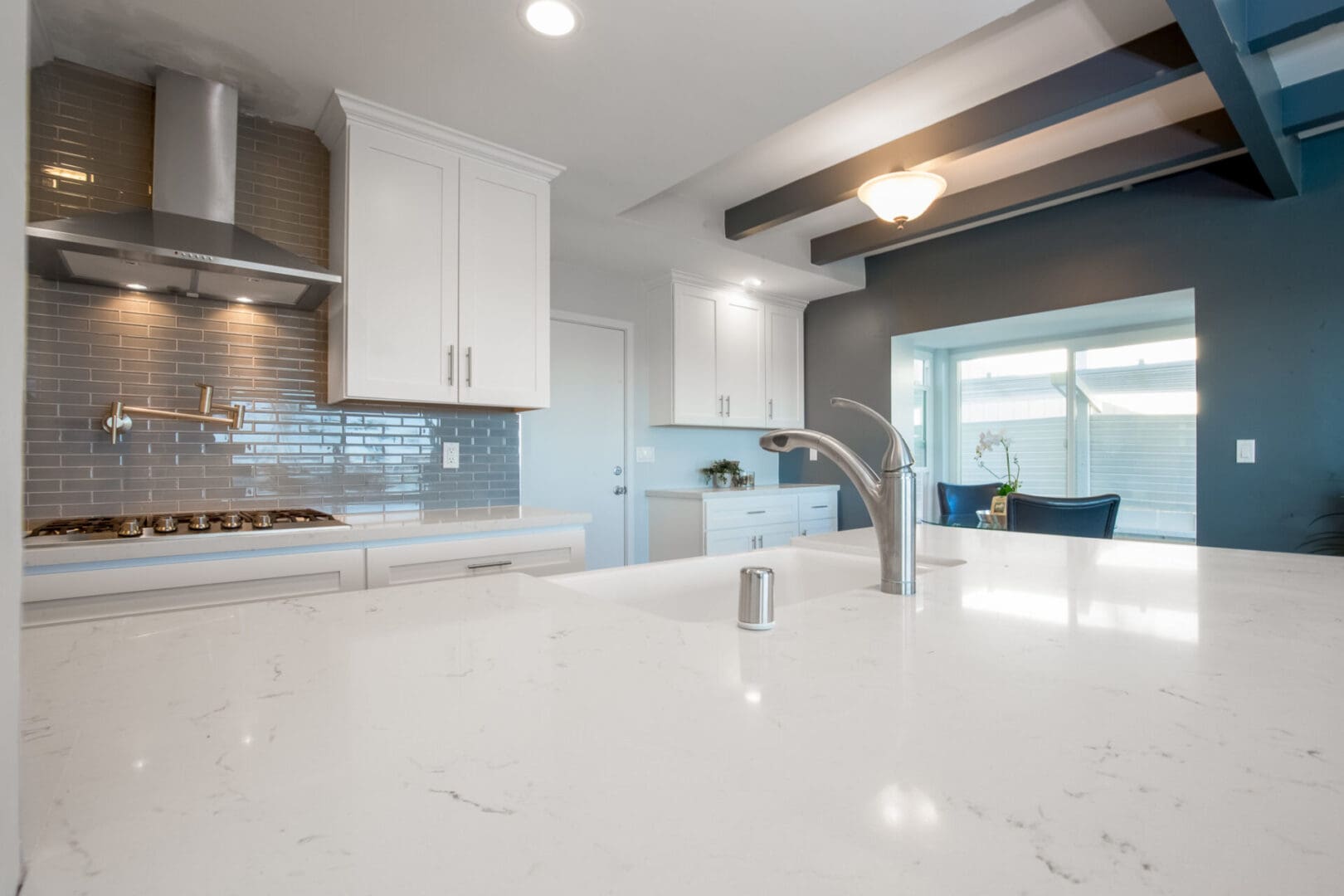 A kitchen with white cabinets and a sink.