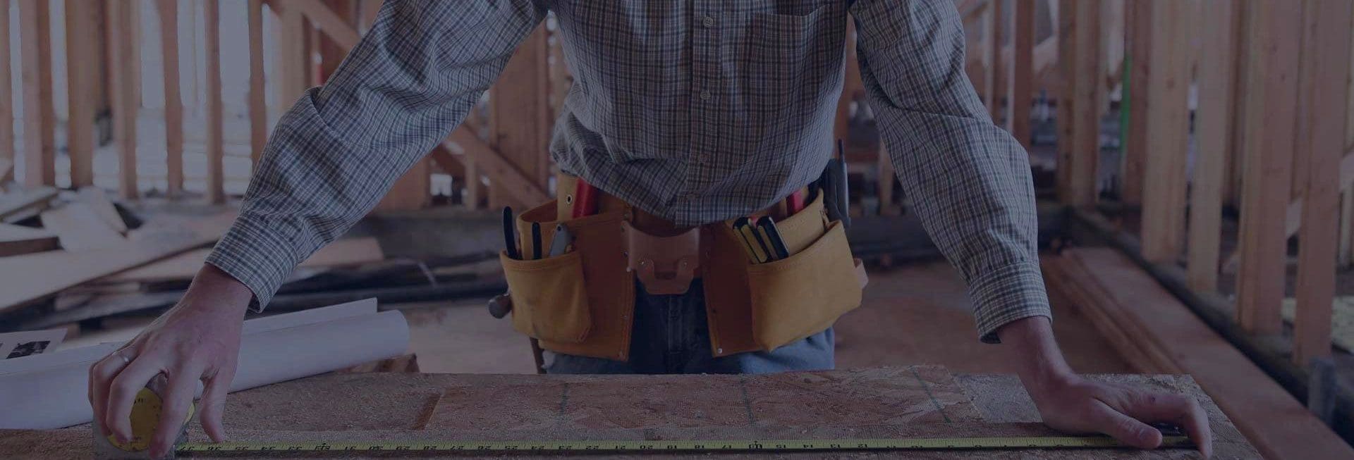 A person with their hands in the pockets of his work pants.